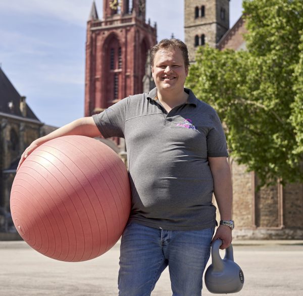 Man met bal en gewicht in zijn handen staat op plein in Maastricht