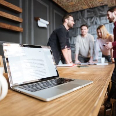 collega's staan tijdens hun overleg omdat zitten ongezond is terwijl zij de tarieven open hebben staan op kantoor