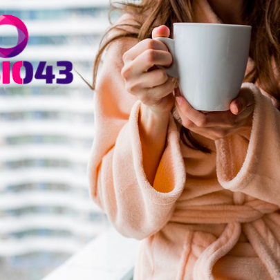 Vrouw drinkt warme drank omdat ze last heeft van nekpijn en schouderklachten bij kou