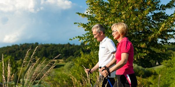 Sporten met artrose Ouder koppel wandelt in de natuur en zijn aan het sporten met artrose