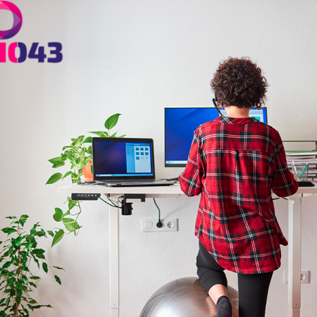 Vrouw staat achter haar bureau en had last van hand- en polsklachten