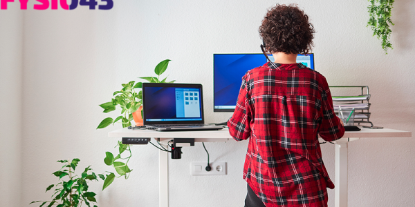 hand- en polsklachten Vrouw staat achter haar bureau en had last van hand- en polsklachten