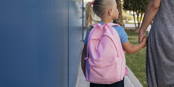 School zonder rugklachten Meisje met roze rugzak gaat naar school zonder rugklachten