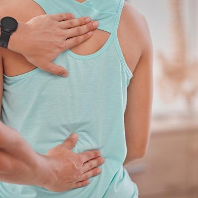 Fysiotherapeut kijkt naar de scoliose van zijn klant
