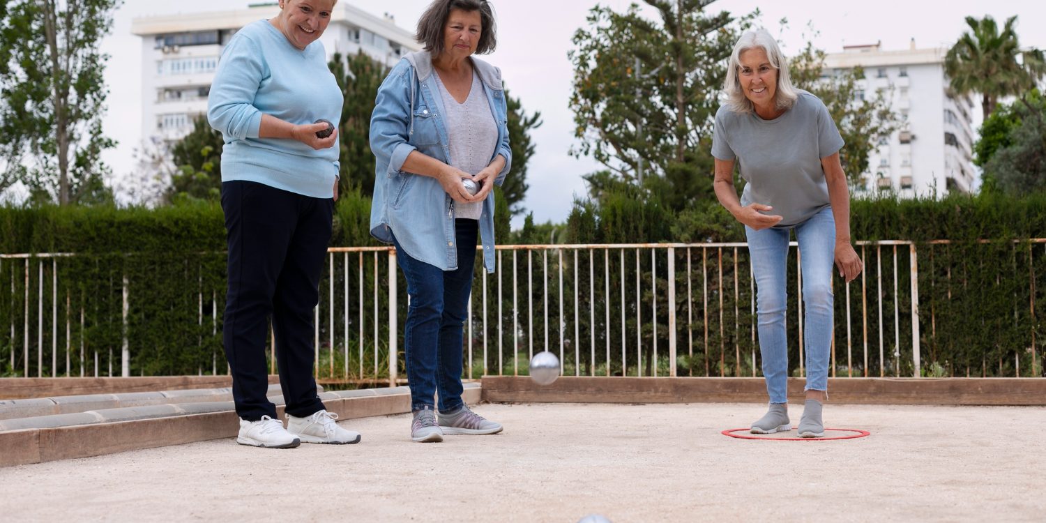 Sport Maastricht Drie ouderen beoefenen de sport jeu de boules en gooien met ballen tijdens zonnig weer