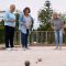 Drie ouderen beoefenen de sport jeu de boules en gooien met ballen tijdens zonnig weer